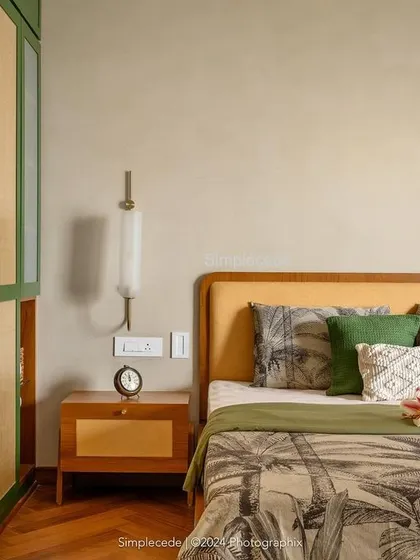 The master bedroom in 'Cover me in Sunshine' is an earthy retreat. The wardrobe, finished in a lush green with rattan panels and custom circular wooden handles, harmonizes with the room's natural and serene character.