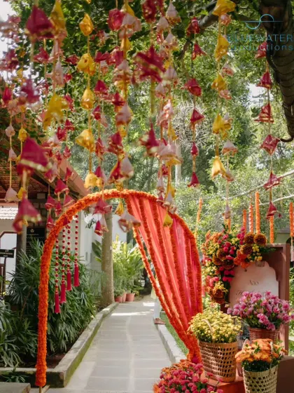 The pathway leading into the Haldi event is a tunnel of flowers and fabric.