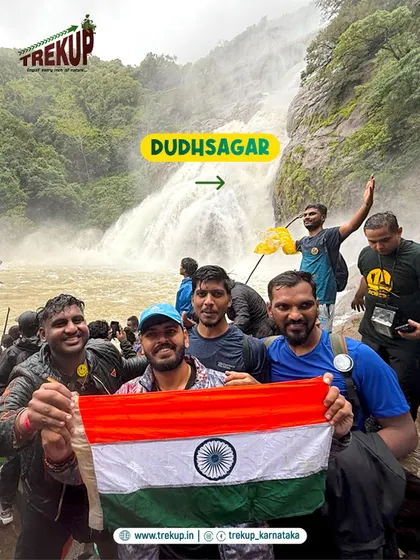 A group of friends proudly holding the flag at Dudhsagar falls. Sharing these powerful moments with others is what makes them so special.
