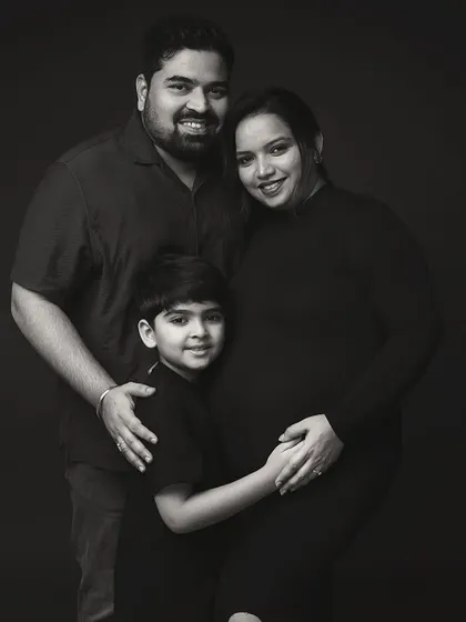 A family portrait, frozen in time. Choosing a black and white palette strips away all distractions, leaving only the pure emotion and connection between a family on the verge of welcoming a new member. This is a true family heirloom.