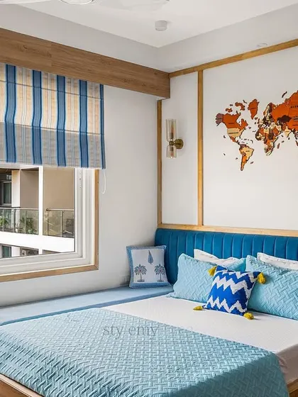A close-up of the bed area, showing the vibrant blue headboard and the custom world map art.