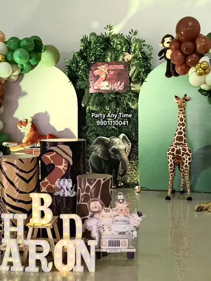 This jungle theme for a 2nd birthday includes animal-print plinths, light-up letters, and a variety of jungle animal cutouts like a cheetah and a lion.