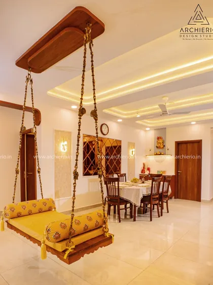 A traditional wooden swing (oonjal) takes center stage in this living room, blending cultural heritage with modern design for a soulful and relaxing space.