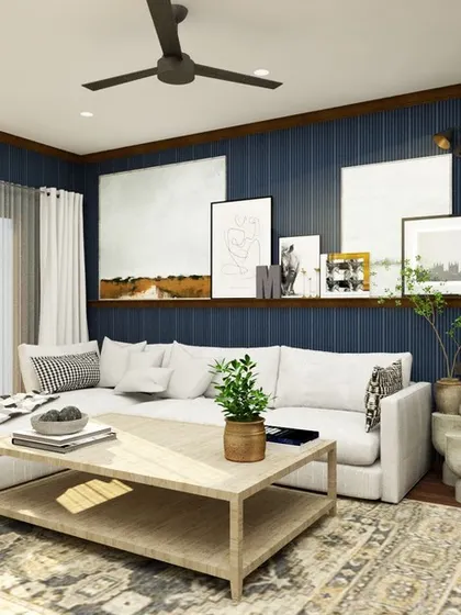 Moody blue vibes create a classy den in this farmhouse-style home. The dark paneled walls, large white sofa, and curated gallery wall make it a stylish and comfortable room to relax and watch movies.