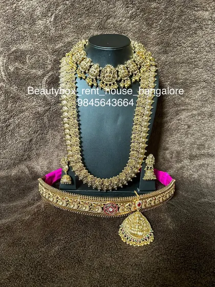 A beautiful antique coin (kasu) necklace set, including a choker, a long kasu haram, and a matching vaddanam. A very popular rental for its traditional appeal.