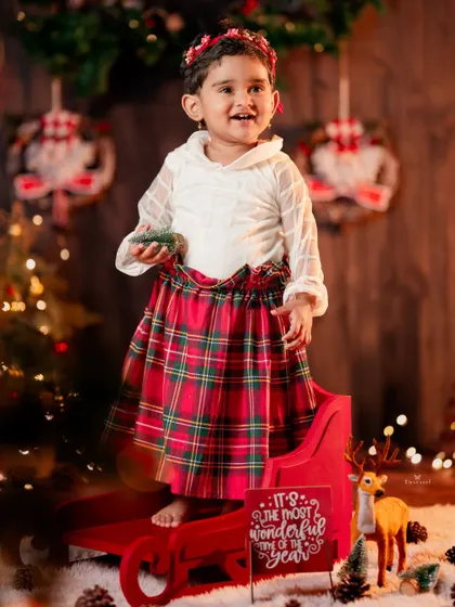 This little girl in her plaid Christmas skirt is ready to help Santa guide his sleigh.