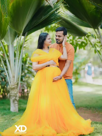 A tender moment captured in a sun-drenched garden. This photo showcases a beautiful yellow gown and the loving connection between the couple in a natural, romantic setting.