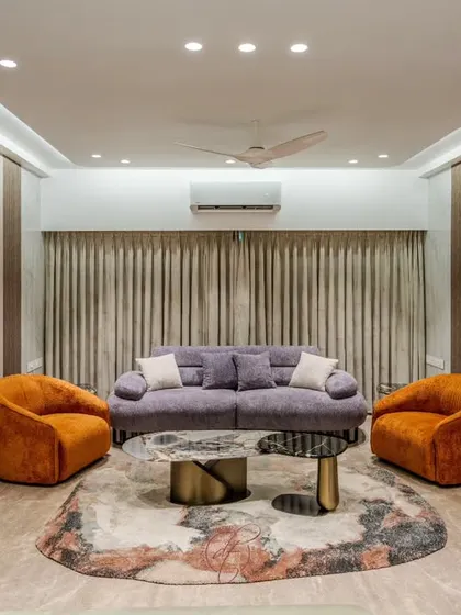A symmetrical view of the living room, showing how the arrangement of the sofa and armchairs creates a perfect space for conversation. The cove lighting adds a soft, ambient glow to the entire room.