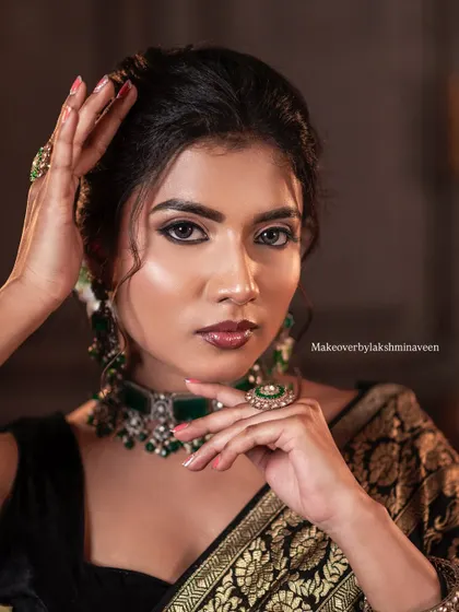 Another portrait from the black saree series, focusing on the hand pose and the stunning green jewelry.