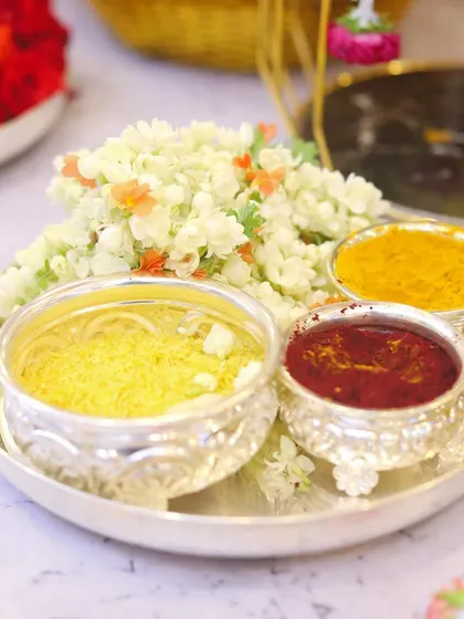 A traditional aarathi plate with turmeric (arishina), kumkum, and akshate in silver bowls, ready for the ceremony. These small details are essential for any auspicious function.