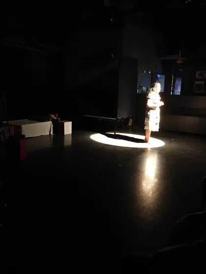 A powerful moment in a solo performance by a student, using a single spotlight to command the audience's attention.
