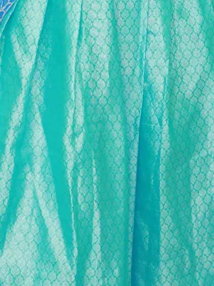A close-up of the aqua brocade skirt, showing the subtle, self-patterned design of the fabric.