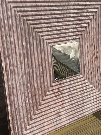 A PVC panel in a light, pinkish wood-grain finish with a silver mirror accent, offering a unique and contemporary style.