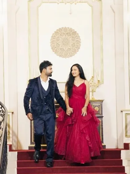 Descending the grand staircase, this couple embodies pure elegance. Her red trail gown flows beautifully, paired with his deep blue velvet suit for a rich, textured look.