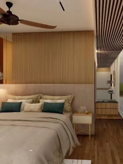A long shot of a bedroom that features a continuous flow of wood from the floor to the wall paneling and the slatted ceiling. This creates a warm, unified look and makes the room feel like a cozy, modern cabin.