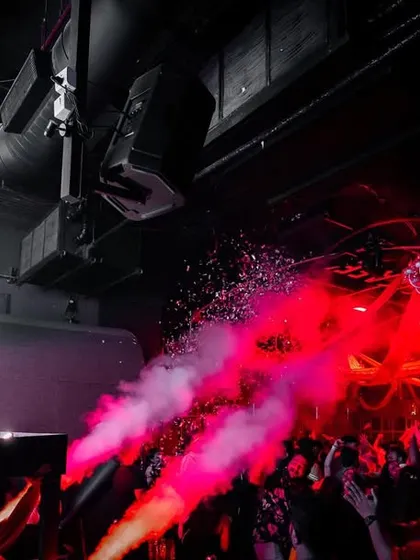 Using colored smoke and confetti to paint the club red. The visual experience is designed to be as dynamic and colorful as the music.