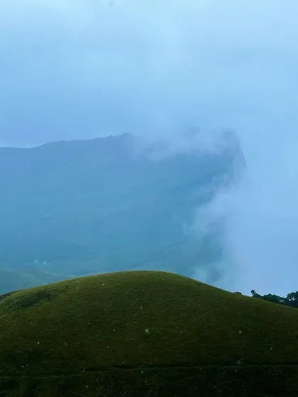 The Kudremukha peak, shaped like a horse's face, peeking through the clouds.