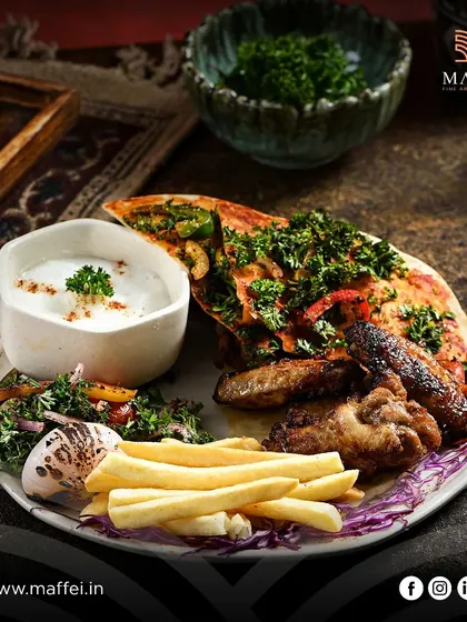 A generous platter of our grilled specialties, including juicy Shish Tawook and Jawaneh Meshwi (chicken wings), served with fries and a side of creamy garlic dip.