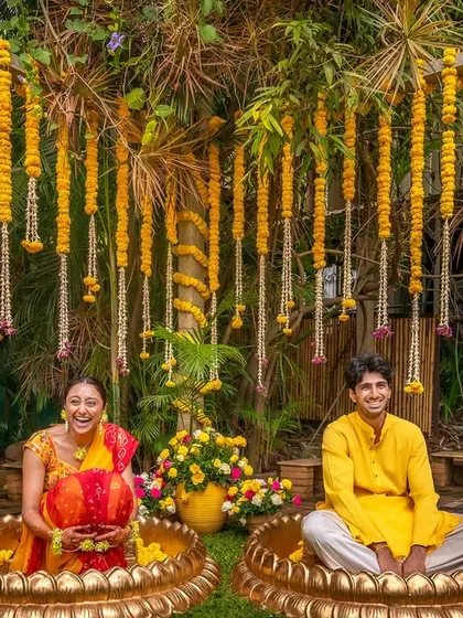 For this unique Haldi setup, the couple sat in large traditional brass 'urulis' filled with flowers, creating a fun and photogenic moment.