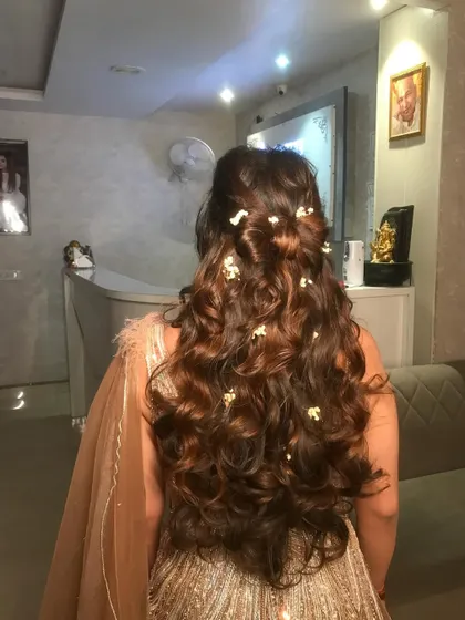Soft, romantic curls are always a beautiful choice for an engagement or reception. We scattered small, fresh flowers throughout the hair to add a delicate and natural touch that complements a flowing gown or lehenga.