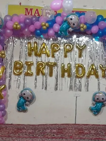 A simple and effective birthday backdrop for a home party. This setup uses a foil curtain, "Happy Birthday" foil letters, and a balloon arch with character accents.