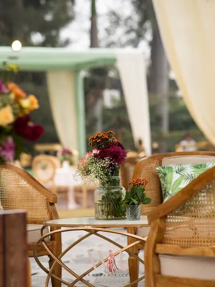A cozy corner of the lounge area, showing the cane furniture and vibrant floral arrangements. This setup was designed to feel like a comfortable and stylish outdoor living room.