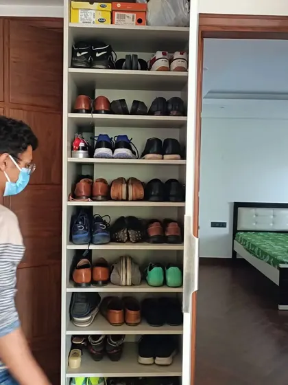 A tall, narrow shoe cabinet with multiple shelves, demonstrating our ability to create custom storage solutions for any need, keeping the home organized and clutter-free.