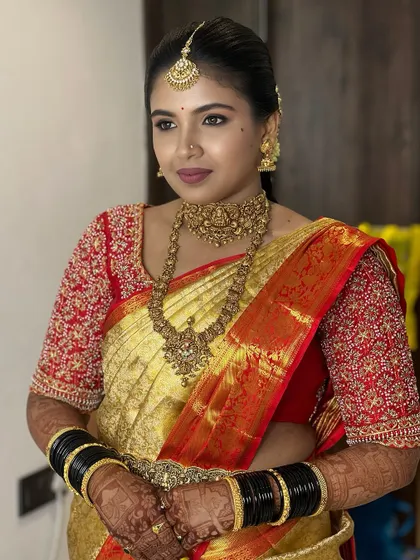 A classic portrait of the bride, showing her complete look with the intricate blouse, heavy jewellery, and a confident pose.