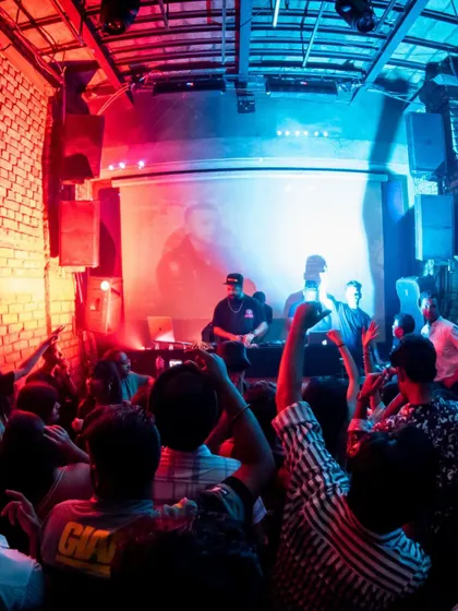 The crowd at Roxy, with hands in the air, fully engaged with the VJ projections and music.