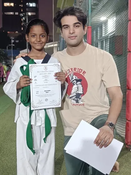 Congratulating a student on her new green belt. I am proud of her progress and hard work.