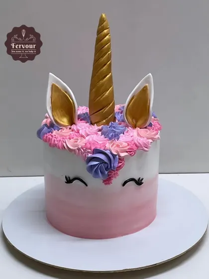 A classic unicorn cake with a golden horn, ears, and a mane of colorful frosting swirls. This is a popular and magical choice for any unicorn-themed party.