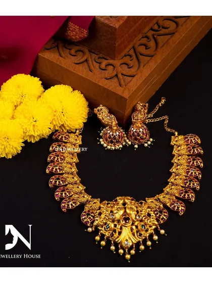 A short temple necklace with intricate carvings and kemp stones. This is a versatile piece that can be worn for various traditional occasions.