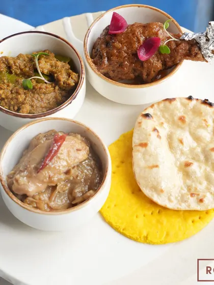A platter from the "Zaika-e-Rooh" pop-up, featuring Chicken Qorma, Chicken Stew, and Mutton Hari Mirchein Keema, served with traditional Sheermal and Tandoori Roti.