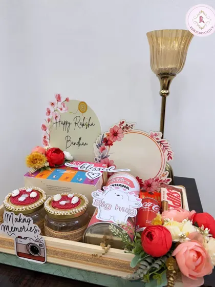 This elegant Rakhi gift tray includes decorated jars, snacks, and a "Happy Raksha Bandhan" plaque. It's a sophisticated and heartfelt way to celebrate your sibling.