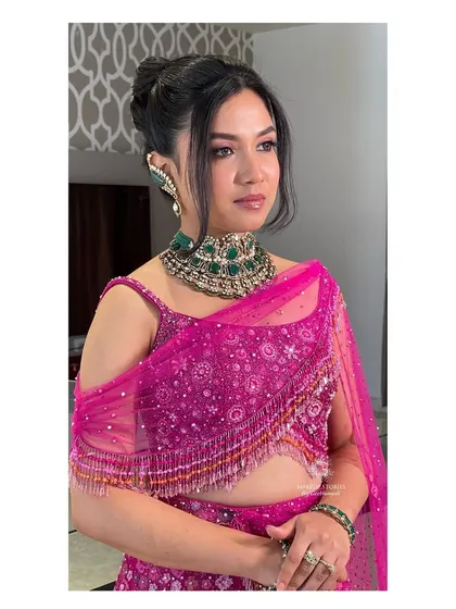 Drutha's modern glam reception look. The messy bun and statement emerald choker create a chic and fashionable vibe.