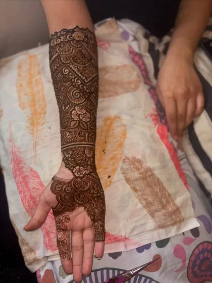 A side view of the engagement bride's henna, showing how the intricate pattern wraps around the arm. Every detail is carefully placed to create a seamless and beautiful design.