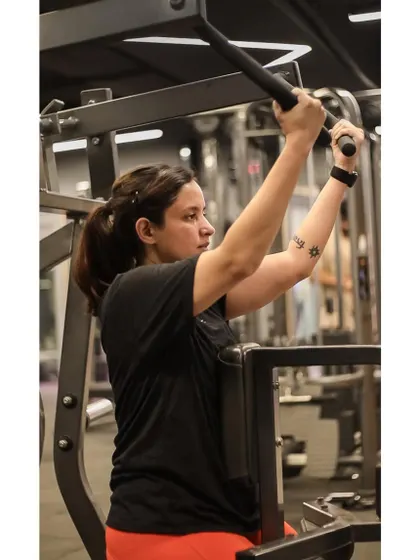 This client works her shoulders using a machine press, which provides a stable and controlled way to build upper body strength.