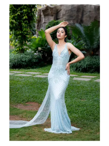 A full-length view of this mermaid-style light blue gown. The sheer train and intricate beadwork create a stunning silhouette from head to toe.