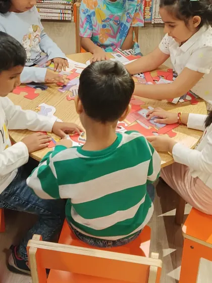 Teamwork makes the dream work! A group of children works together to solve a large floor puzzle, developing problem-solving and collaboration skills while having a blast.