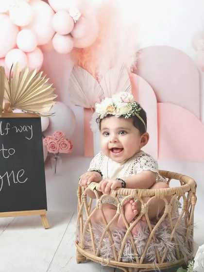 Halfway to one is a milestone worth celebrating. This adorable half-birthday shoot features a beautiful pink boho theme with a custom chalkboard sign to mark the special occasion.