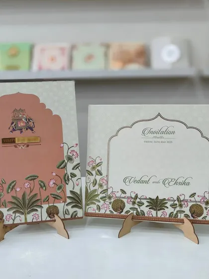 A beautiful Pichwai-themed invitation with a unique opening style. The card features an elephant motif and a gold acrylic nameplate.