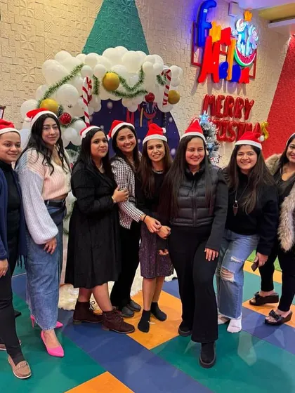 A group of moms enjoying the Christmas party, all wearing Santa hats and getting into the festive spirit.