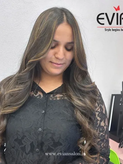 The client's happy expression shows her satisfaction with her new highlights. The face-framing pieces brighten her complexion and complete the look.