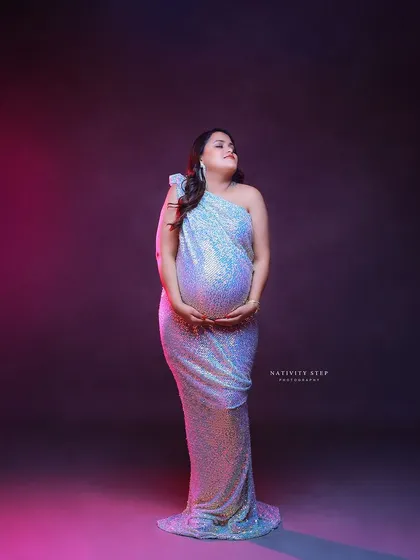 A stunning solo portrait in a shimmering sequined gown. The dramatic pink and purple lighting creates a modern and high-fashion look.