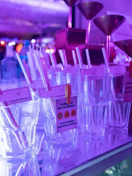 Personalized details at the bar, with quirky quotes and the couple's hashtag on the drink stirrers. These small touches show a high level of personalization and care.