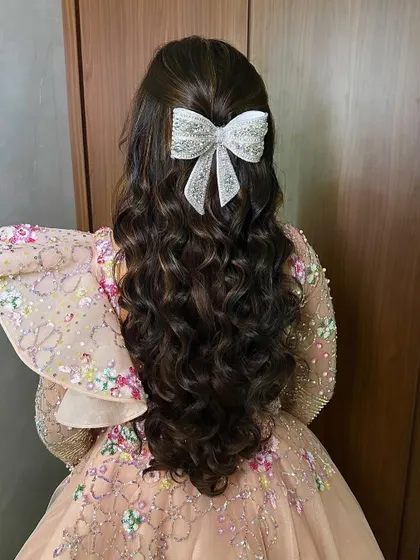 The back view of the princess hairstyle, highlighting the large, sparkling bow.