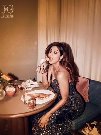 A moment of indulgence. Shilpa Shetty enjoys a slice of pizza while dazzling in our diamond jewellery, proving that glamour is for every occasion.