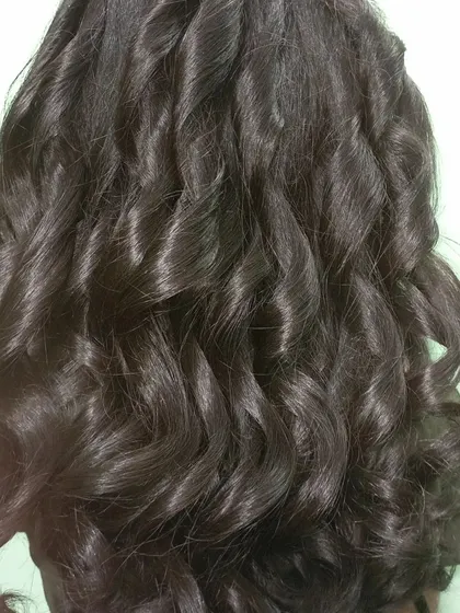 A close-up of these gorgeous, glossy curls. This shows the texture and definition I can create, perfect for adding volume and bounce to your hair.