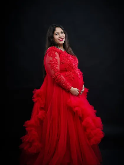 A classic solo portrait in our dramatic red gown. The long sleeves with lace detail and the voluminous skirt create a look of pure elegance against the dark backdrop.