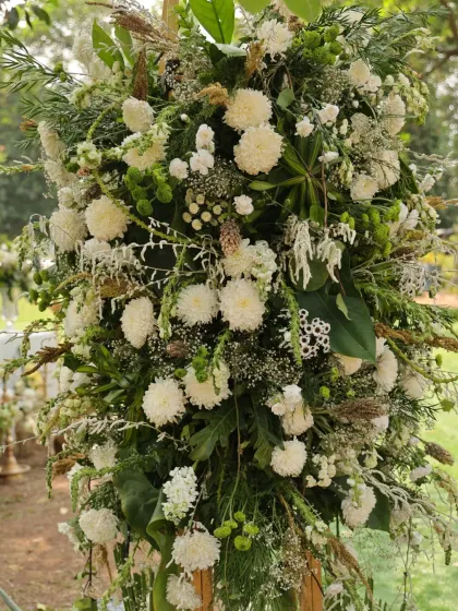 A dense and textured floral arrangement, using a variety of white flowers and greenery for a rich, organic look.